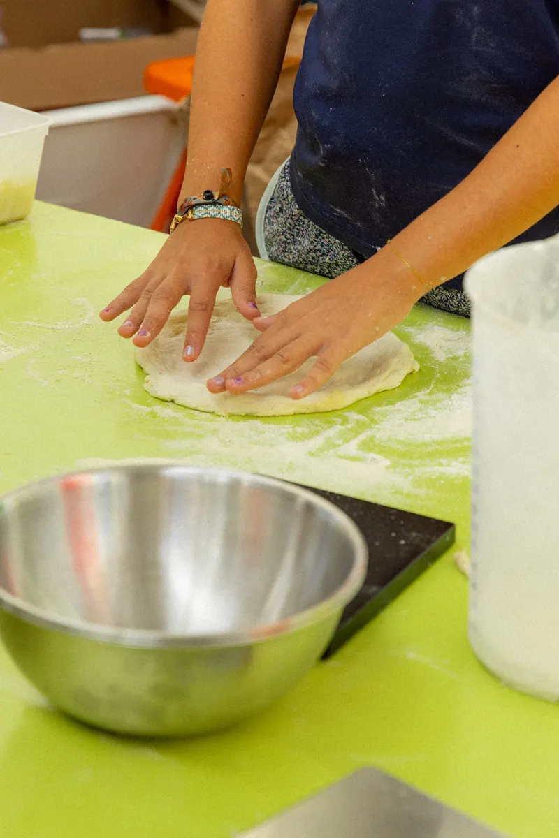 Mains qui étalent la pâte à pizza sur le plan de travail