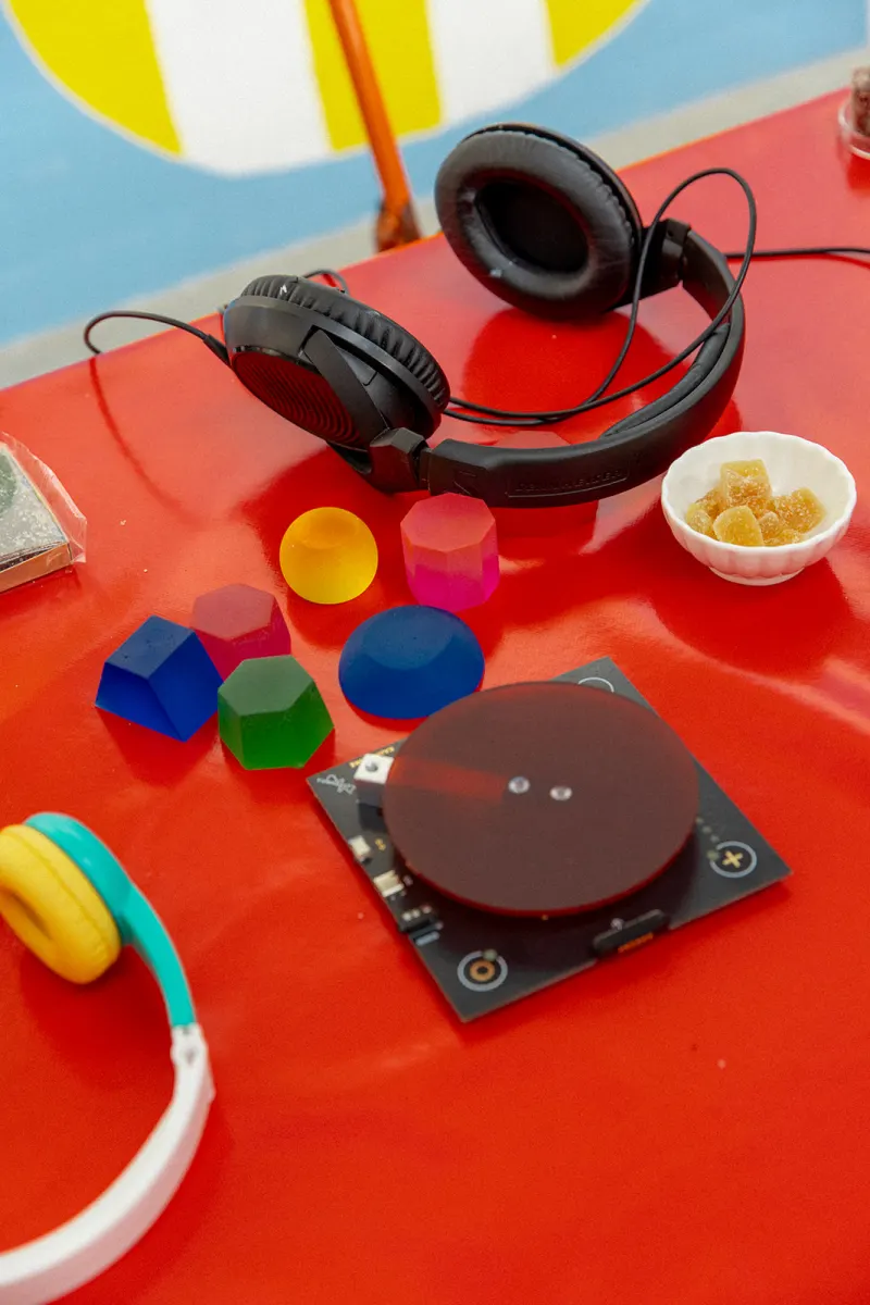 Table rouge avec casques audio et formes colorées