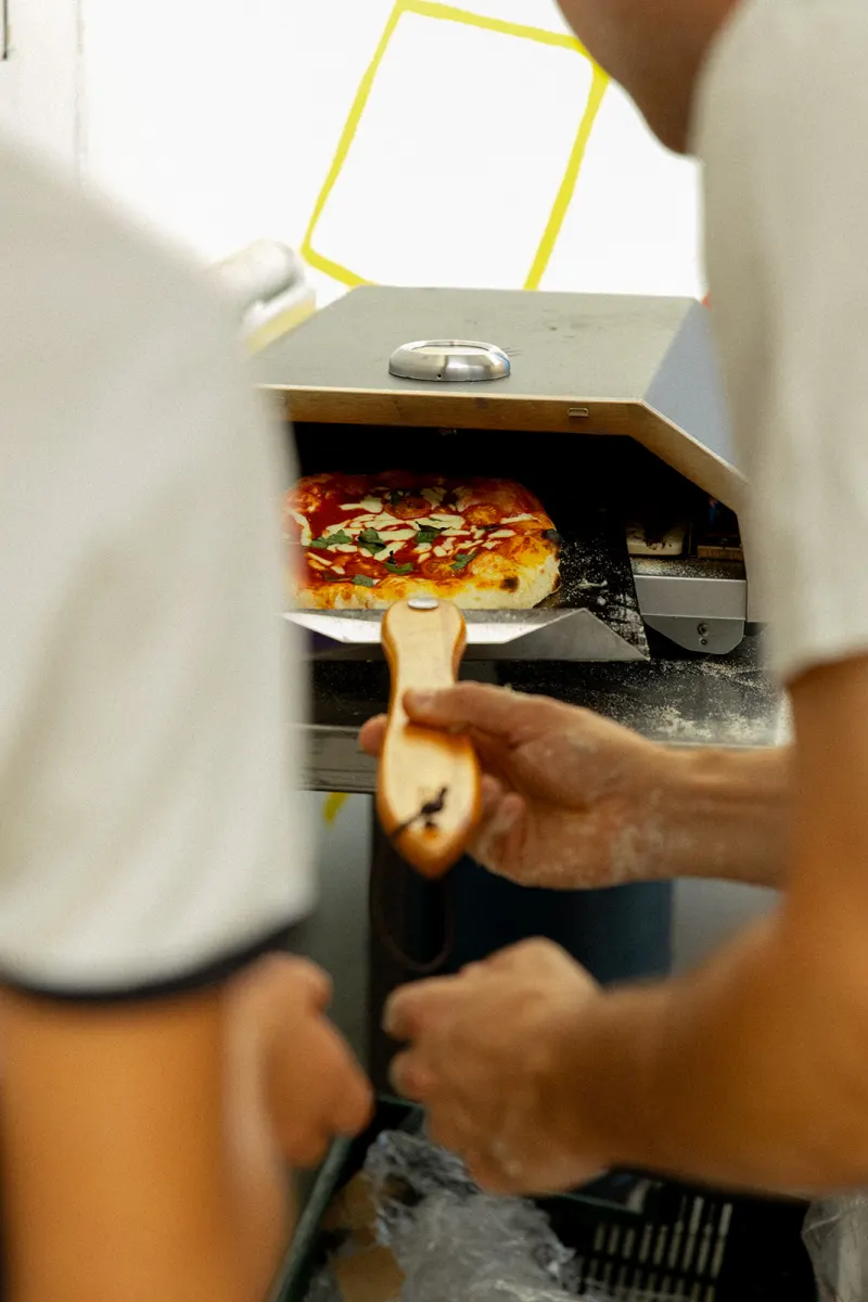 Pizza enfournée dans le four du stand