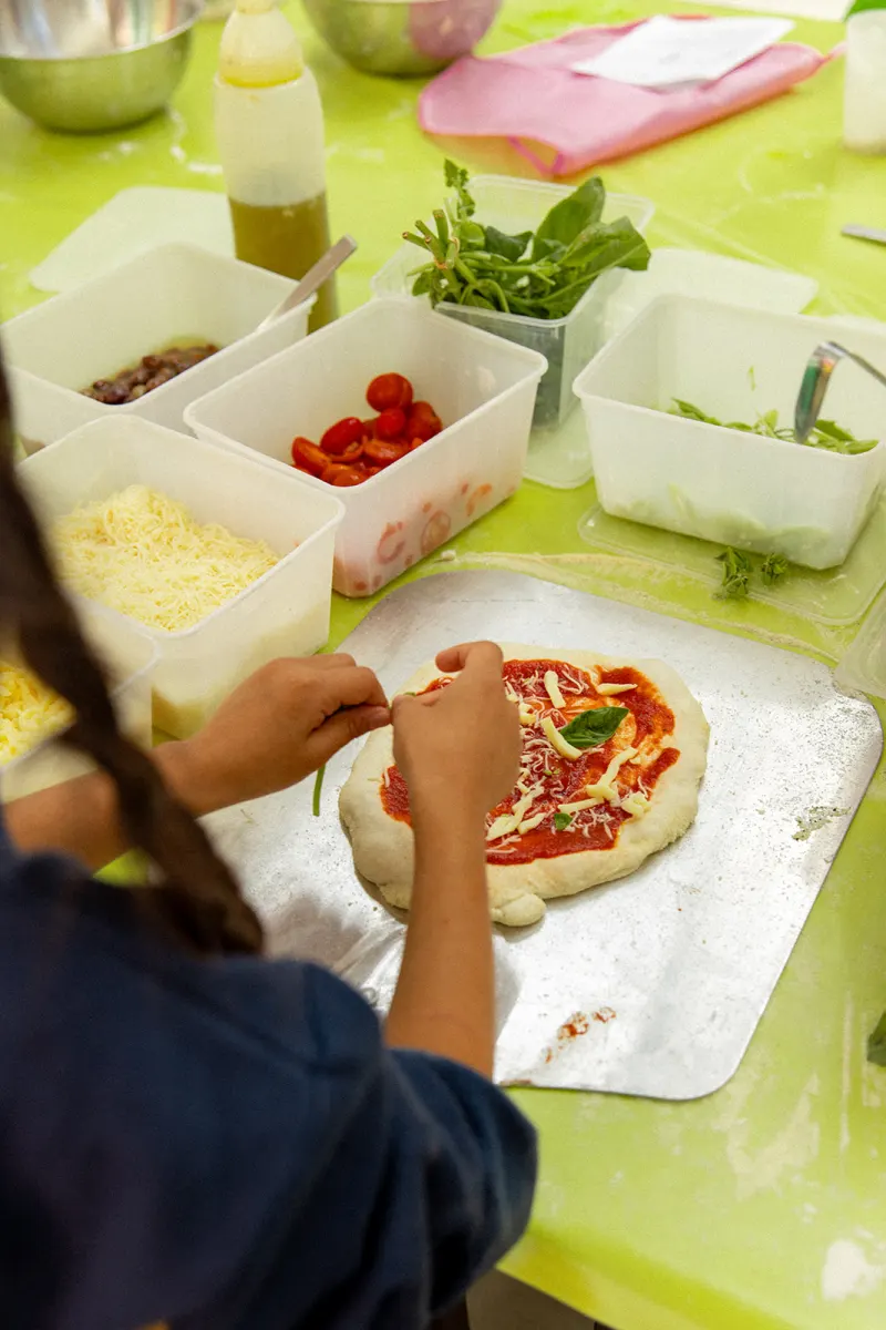Garniture d'une pizza pendant l'atelier
