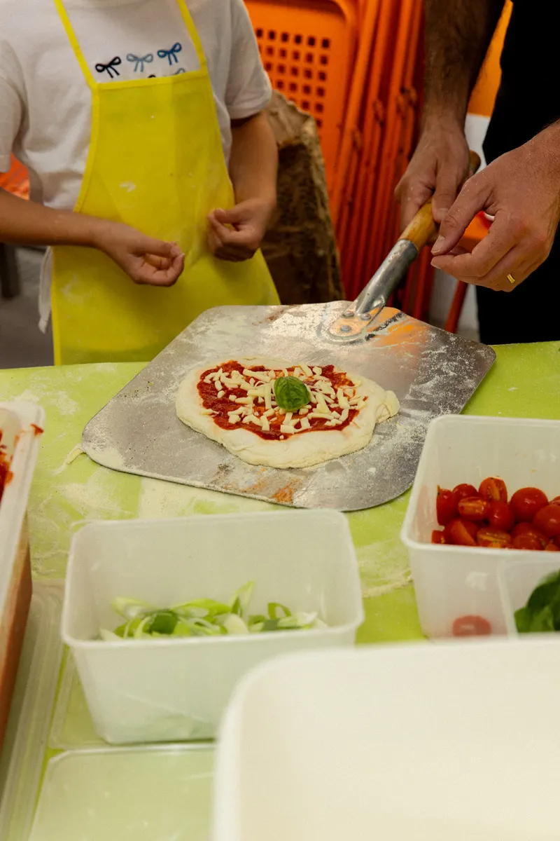 Pizza garnie posée sur la pelle, prête à enfourner